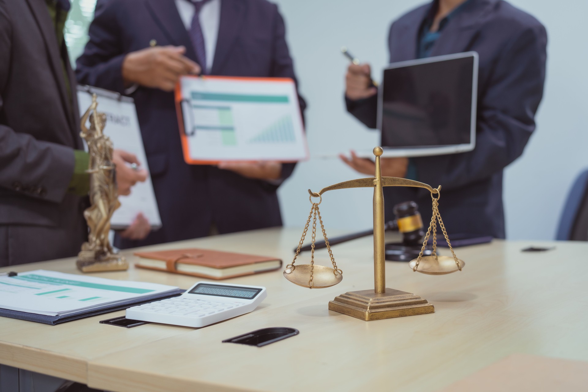 Three lawyers in a meeting at the table in an office, discussing business, civil and commercial law, labor law, marketing and advertising law,offering legal consulting and case management services.